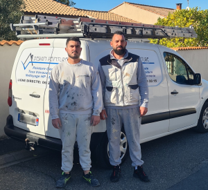 Deux peintres en bâtiment posent devant leur utilitaire chargé d’échelles