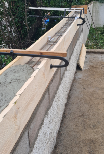 Coffrage d’un muret en béton armé, avec ferraillage apparent et étais métalliques